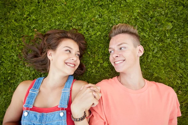 Gelukkig tiener paar liggend op gras in de zomer — Stockfoto