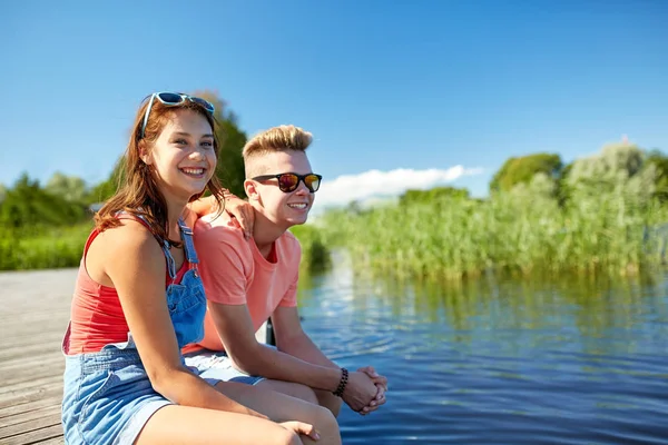 Gelukkig tiener paar zitten op rivier ligplaats — Stockfoto