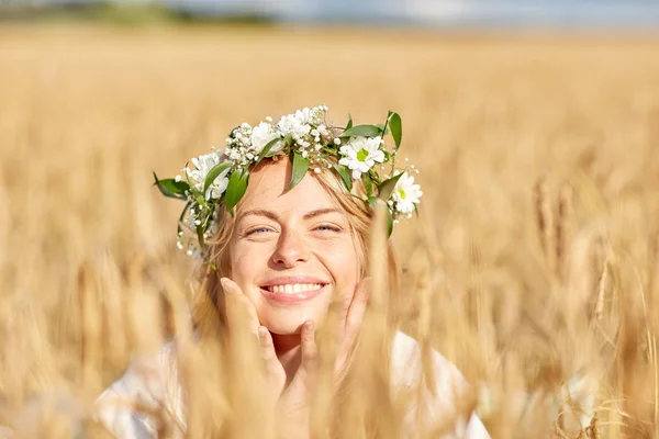 Gelukkig vrouw in krans van bloemen op graan veld — Stockfoto