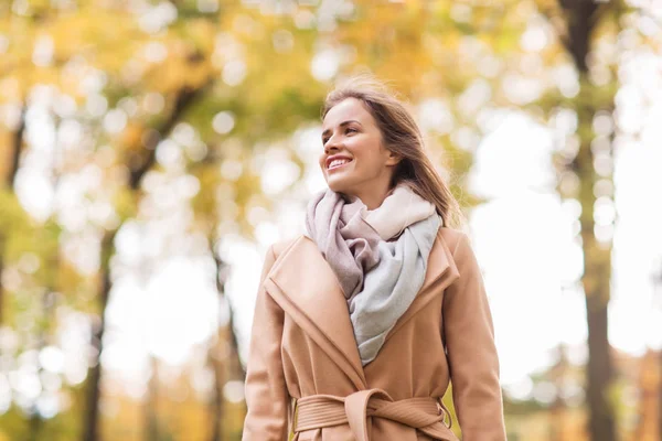 Schöne glückliche junge Frau, die im herbstlichen Park spaziert — Stockfoto