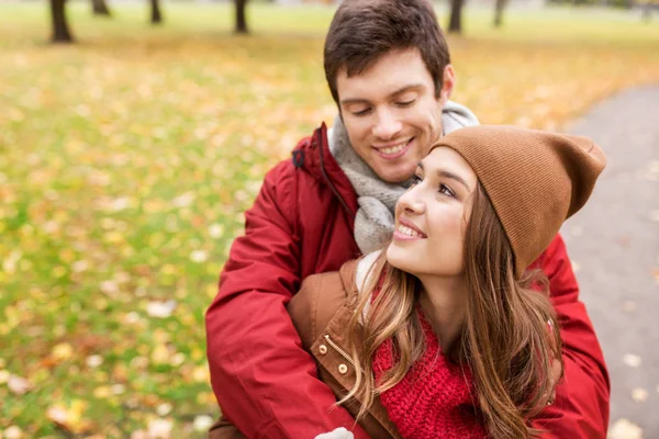 Feliz pareja joven abrazándose en el parque de otoño — Foto de Stock