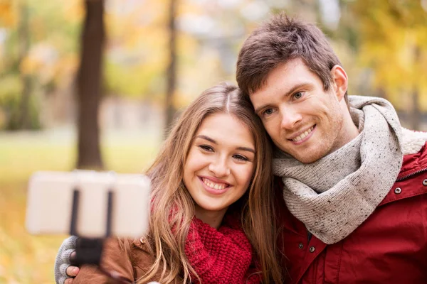 Couple taking selfie by smartphone in autumn park — Stock Photo, Image
