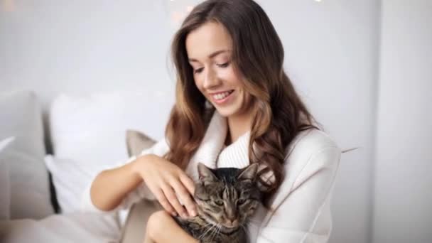 Jovem feliz com gato na cama em casa — Vídeo de Stock