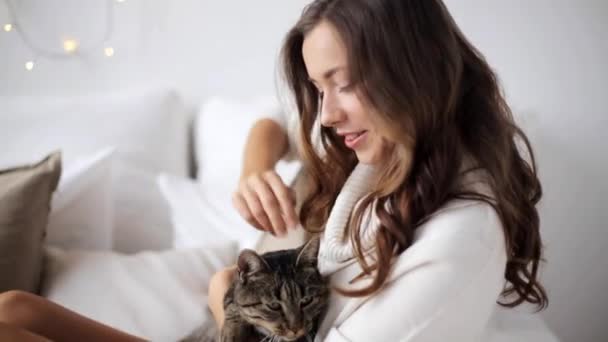 Feliz joven con gato en la cama en casa — Vídeos de Stock