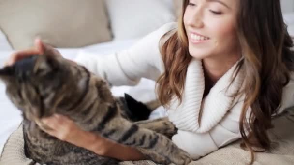 Feliz joven con gato en la cama en casa — Vídeos de Stock