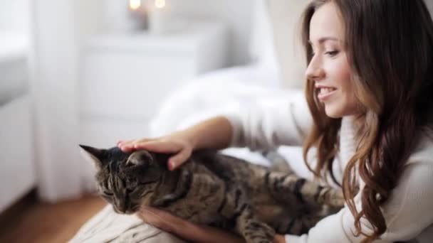 Щаслива молода жінка з кішкою в ліжку вдома — стокове відео