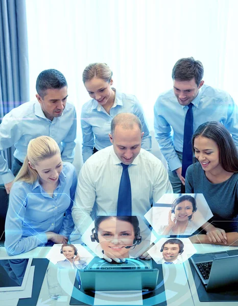 Pessoas de negócios sorridentes com laptop no escritório — Fotografia de Stock
