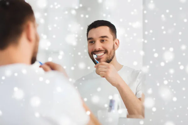 Uomo con spazzolino da denti pulizia denti in bagno — Foto Stock