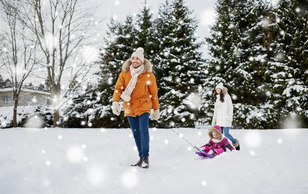 Щаслива сім'я з санчатами, що ходять взимку на відкритому повітрі — стокове фото