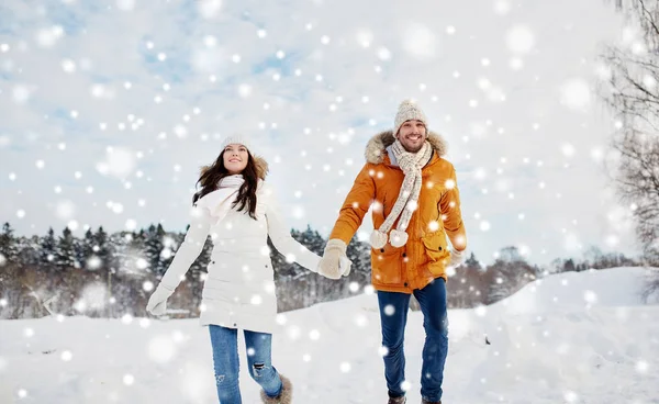 幸福的夫妇，在冬天的雪中运行 — 图库照片