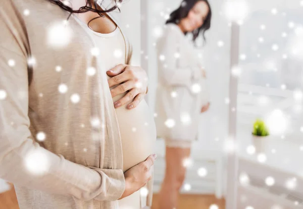 Primer plano de la mujer embarazada mirando al espejo — Foto de Stock