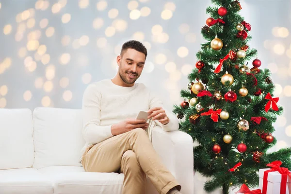 Smiling man with smartphone for christmas — Stock Photo, Image