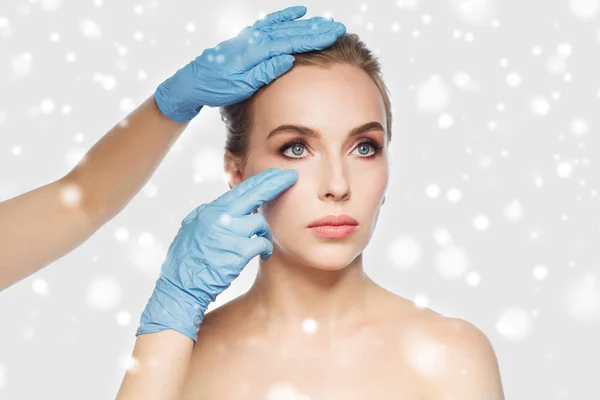 Chirurg of schoonheidsspecialiste handen aanraken van gezicht vrouw — Stockfoto