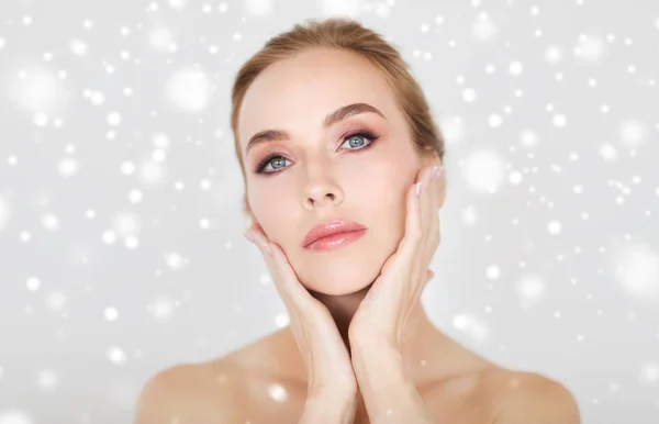 Beautiful young woman face and hands over snow — Stock Photo, Image