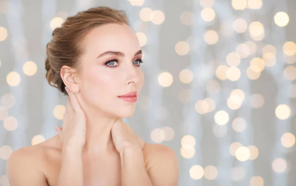 Hermosa mujer tocando su cuello sobre luces —  Fotos de Stock