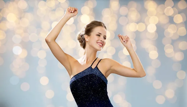 Mulher sorridente dançando com as mãos levantadas — Fotografia de Stock
