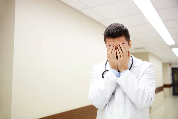 Λυπημένος ή κλάμα αρσενικό ο γιατρός στο διάδρομο του νοσοκομείου — Φωτογραφία Αρχείου