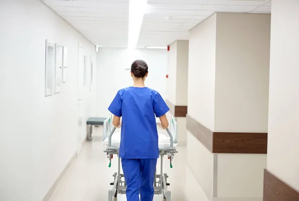 Enfermera llevando camilla del hospital a la sala de emergencias — Foto de Stock
