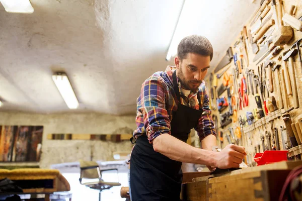 Carpenter working with plane and wood at workshop — Stock Photo, Image