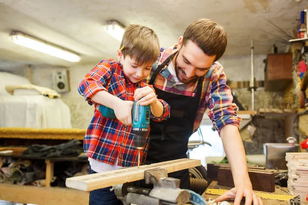 Apa és fia, fúróval műhelyében dolgozik — Stock Fotó