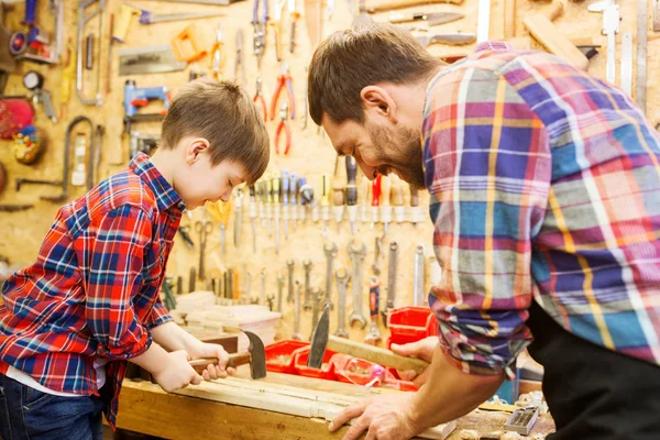 Pai e filho com martelo trabalhando na oficina — Fotografia de Stock