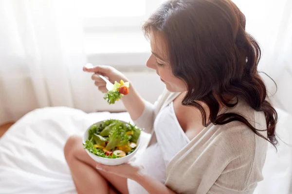 Close-up de mulher grávida comendo salada em casa — Fotografia de Stock