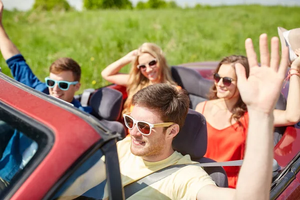 Amigos felizes dirigindo em carro cabriolet no país — Fotografia de Stock