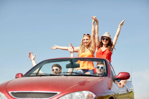 Amigos felizes dirigindo em carro cabriolet no país — Fotografia de Stock