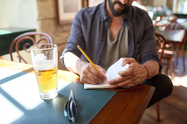 Close up de homem com cerveja e caderno no pub — Fotografia de Stock