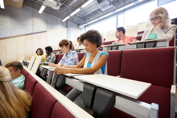 Grupa studentów z notatnikami w sali wykładowej — Zdjęcie stockowe