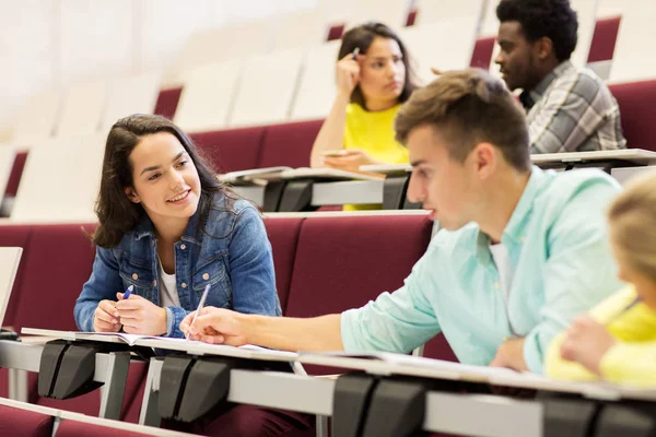 Grupo de estudiantes con cuadernos en la sala de conferencias — Foto de Stock