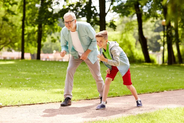 Abuelo y nieto corriendo en el parque de verano — Foto de Stock