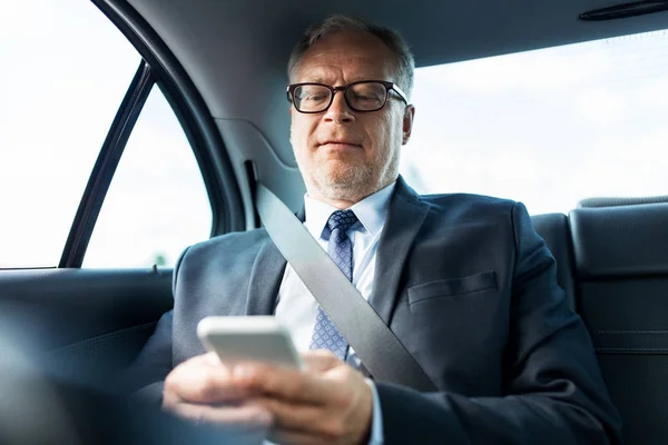 Empresário sênior de mensagens de texto no smartphone no carro — Fotografia de Stock