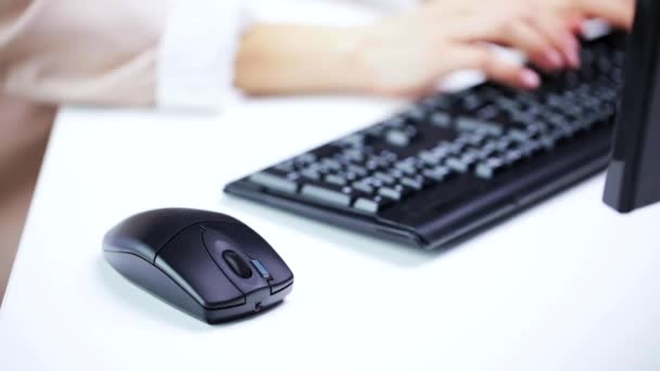 Женские руки, печатающие на клавиатуре компьютера в офисе — стоковое видео