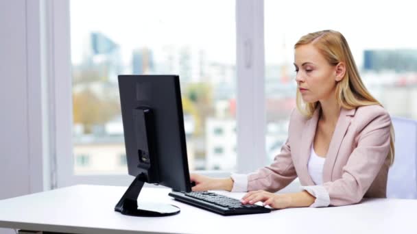 Joven empresaria con computadora escribiendo en la oficina — Vídeos de Stock