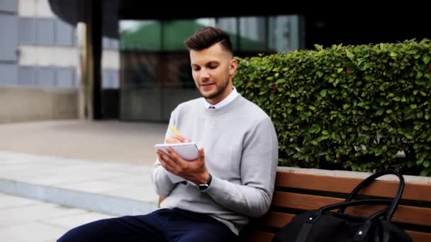 Homme avec cahier ou journal écrit sur la rue de la ville — Video