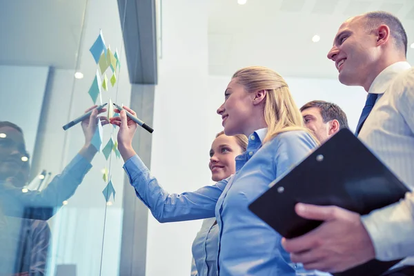 Smiling business people with marker and stickers — Stock Photo, Image