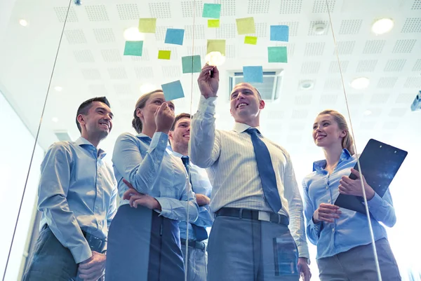 Smiling business people with marker and stickers — Stock Photo, Image