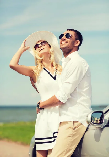 Lycklig man och kvinna som kramas nära bil till sjöss — Stockfoto