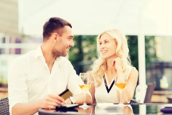 Feliz pareja con tarjeta bancaria y factura en el restaurante —  Fotos de Stock