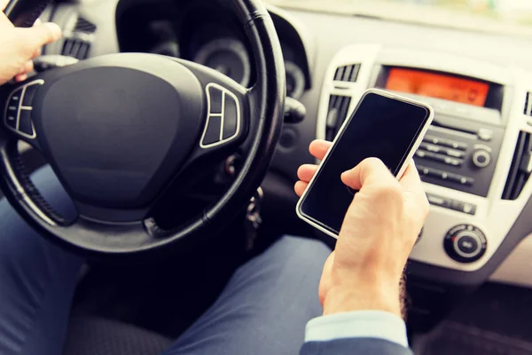 Закрыть руку человека со смартфоном за рулем автомобиля — стоковое фото