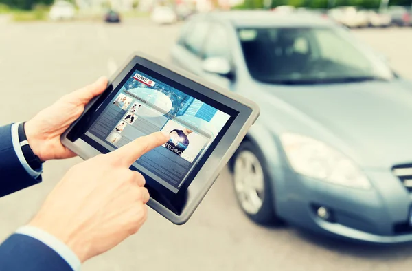 Närbild av händer med nyheter om TabletPC och bil — Stockfoto