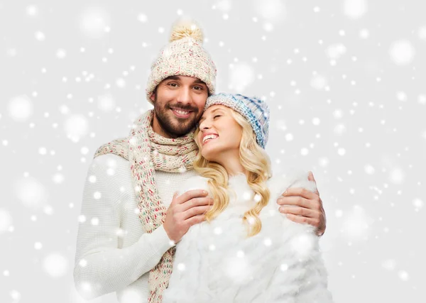 Usmívající se pár v zimní oblečení objímání po sněhu — Stock fotografie