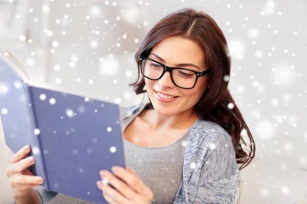 Giovane donna in occhiali lettura libro a casa — Foto Stock