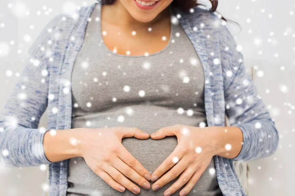 Close up van gelukkig zwangere vrouw maken van hart — Stockfoto