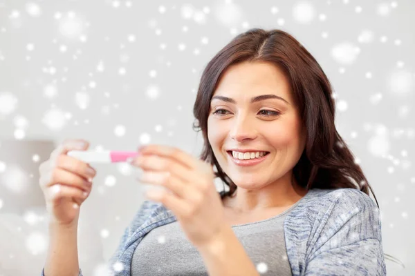 Счастливая женщина смотрит на домашний тест на беременность — стоковое фото