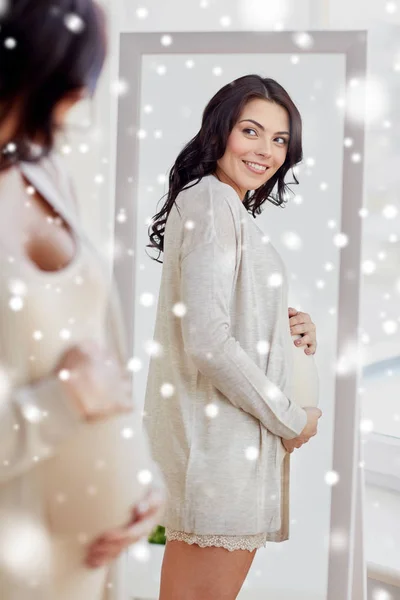 Glückliche schwangere Frau schaut zu Hause in den Spiegel — Stockfoto