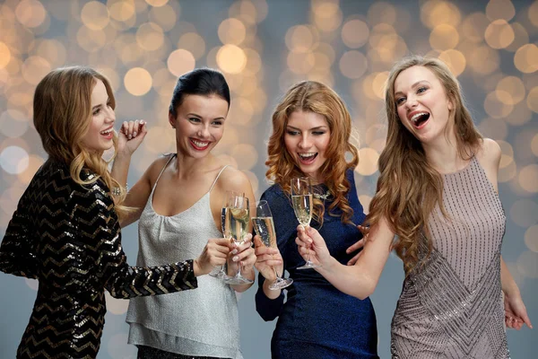 Femmes heureuses cliquetis verres à champagne sur les lumières — Photo