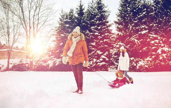 Família feliz com trenó andando no inverno ao ar livre — Fotografia de Stock