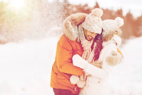 Счастливая пара обнимается и смеется зимой — стоковое фото